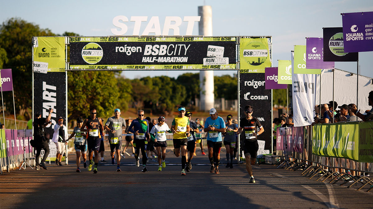 Imagem de corredores no pórtigo de largada da BSB City Marathon.