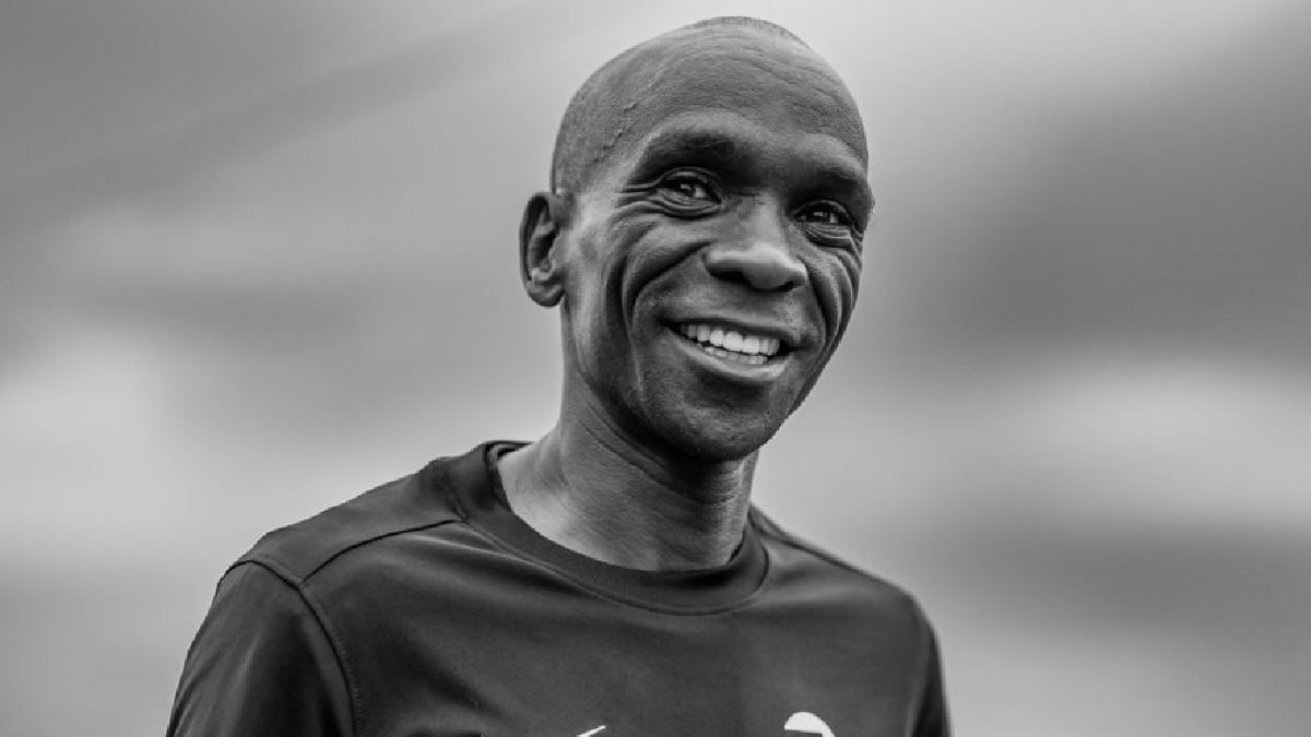 Imagem de Eliud Kipchoge em preto e branco. Ele sorri para a foto.