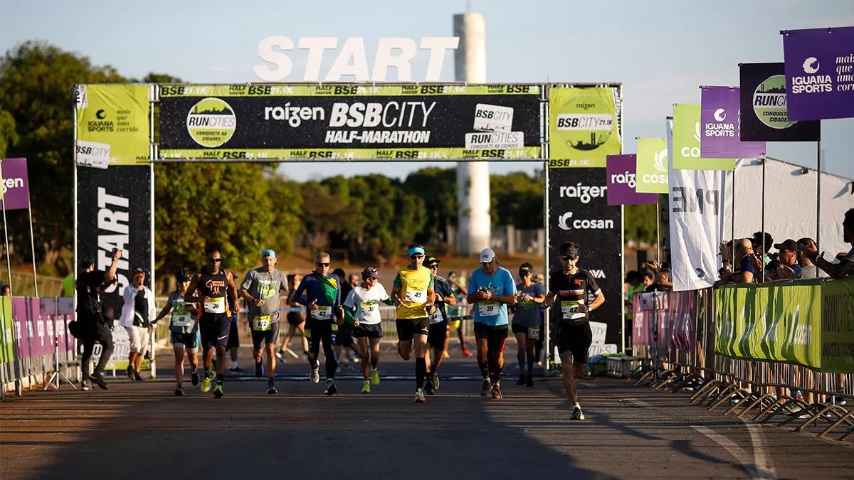 Imagem de corredores no pórtigo de largada da BSB City Marathon.
