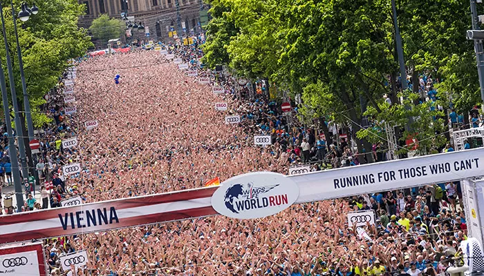 Foto de rua lotada de corredores antes da largada.