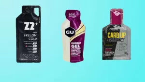 Embalagens de três marcas de gel de carboidrato em um fundo azul claro.